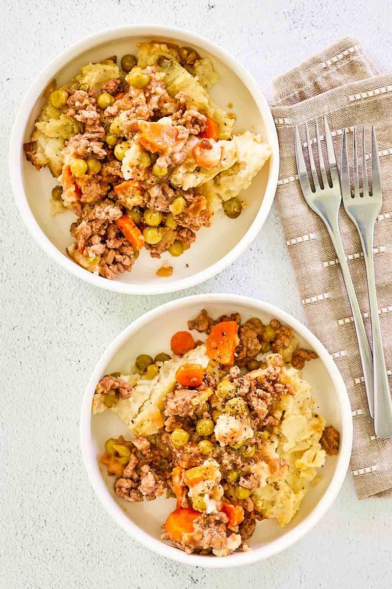 Overhead view of two bowls of homemade shepherd's pie with beef.