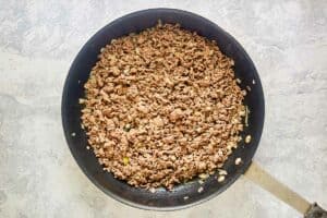 Browned ground beef in a skillet.