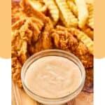 Homemade Zaxby's Zax sauce in a bowl, fried chicken tenders, and crinkle fries.