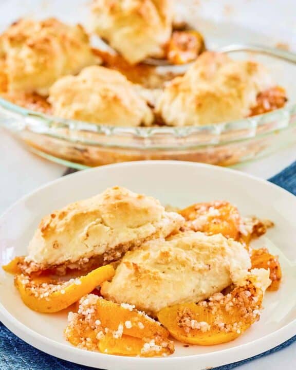Bisquick peach cobbler on a plate and in a pie plate.
