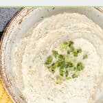 Overhead view of homemade boursin cheese spread garnished with chopped green onions.