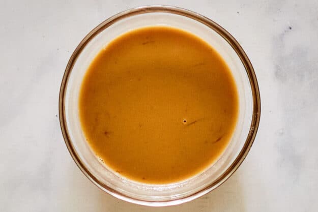 Egg yolk and onion soup mixture in a bowl.