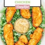 Overhead view of homemade Planet Hollywood Captain Crunch chicken on top of kale on a platter.