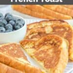 Homemade Cracker Barrel French toast and a bowl of blueberries on a white plate.