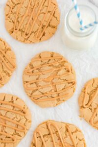 Overhead view of copycat Crumbl ultimate peanut butter cookies and a glass of milk.