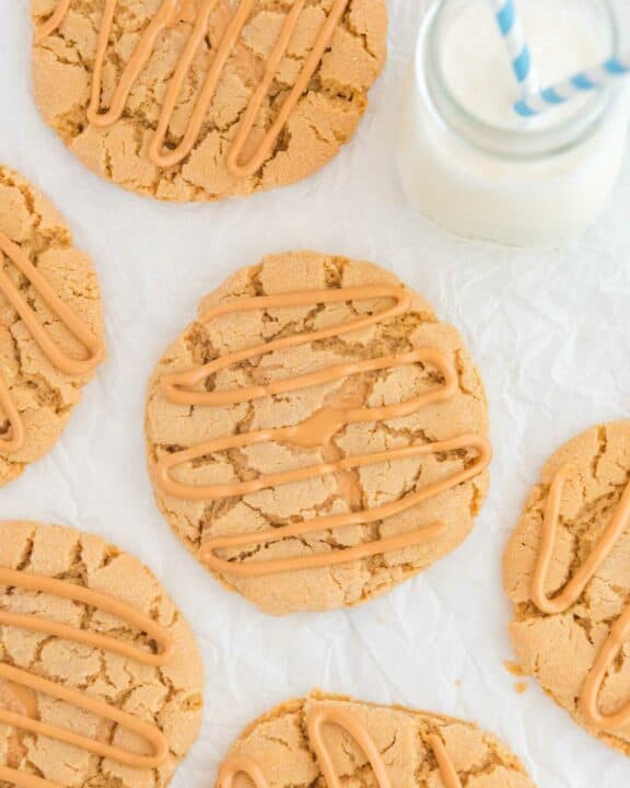 Overhead view of copycat Crumbl ultimate peanut butter cookies and a glass of milk.