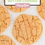 Overhead view of homemade Crumbl ultimate peanut butter cookies scattered on a marble surface.