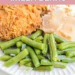Homemade KFC green beans on a plate with chicken and potatoes.