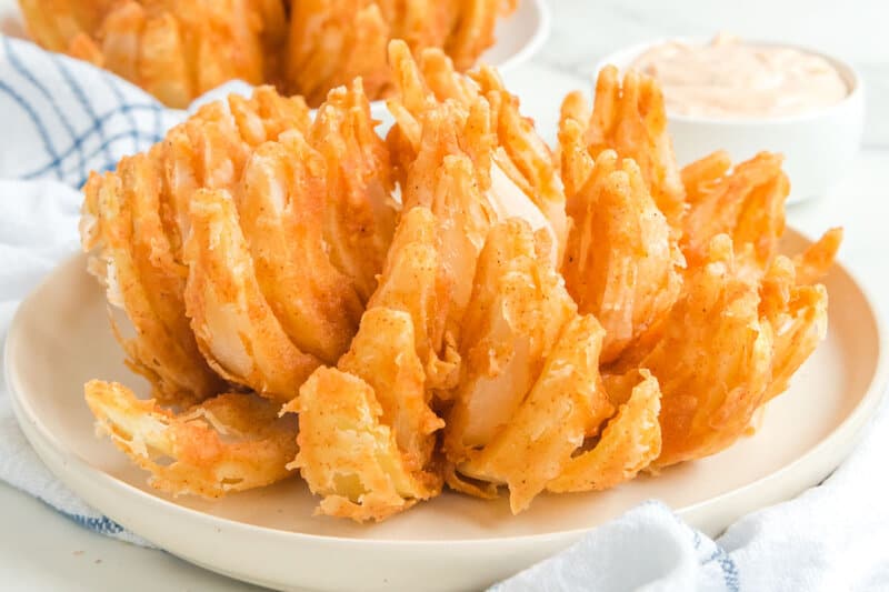 Copycat Outback bloomin onion and a bowl of dipping sauce.