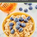 A bowl of overnight oats topped with honey and fresh blueberries.