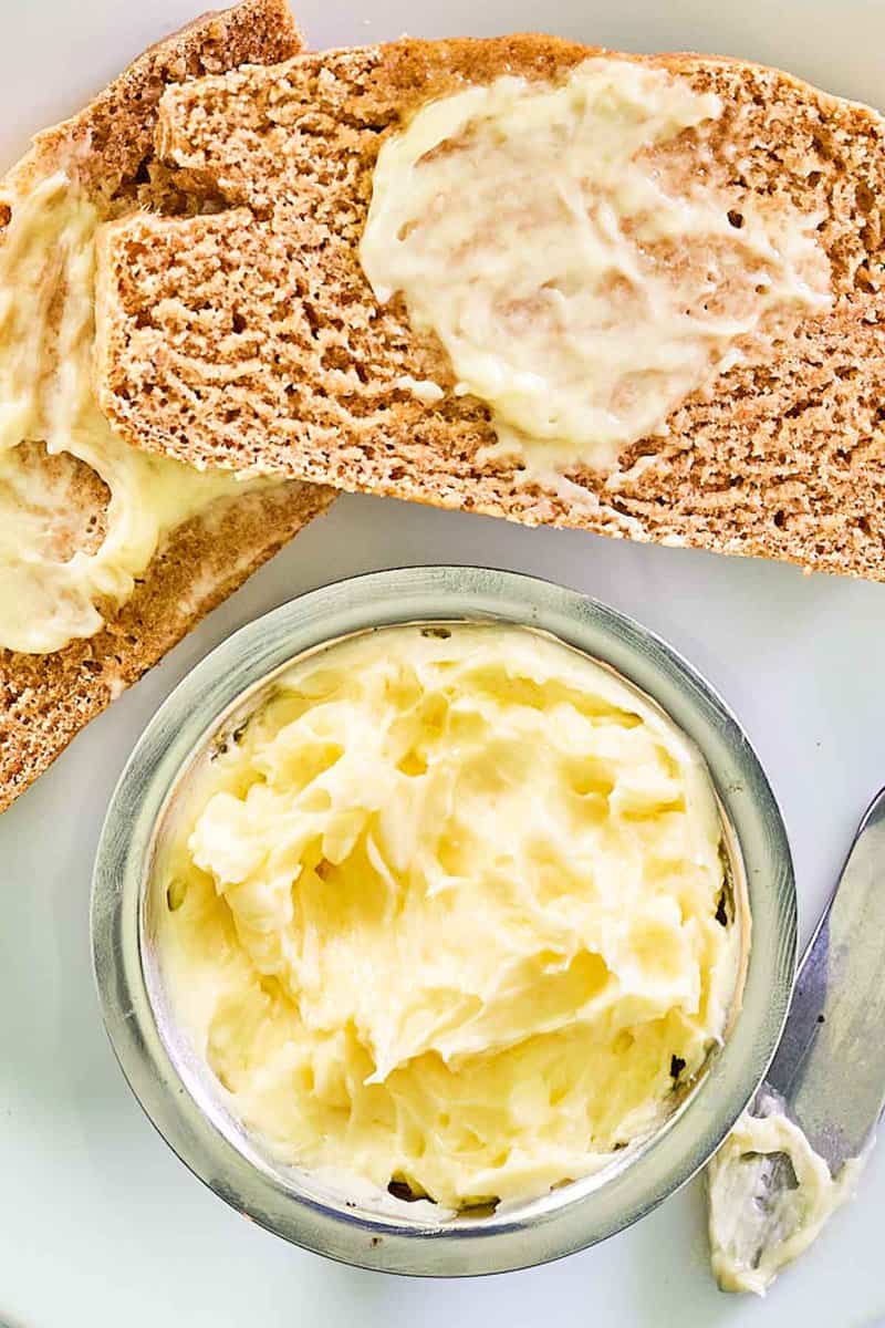 Overhead view of copycat Saltgrass Steakhouse honey butter in a bowl and on bread slices.