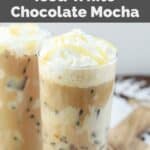 Homemade Starbucks iced white chocolate mocha drink with whipped cream and white chocolate drizzle on top.