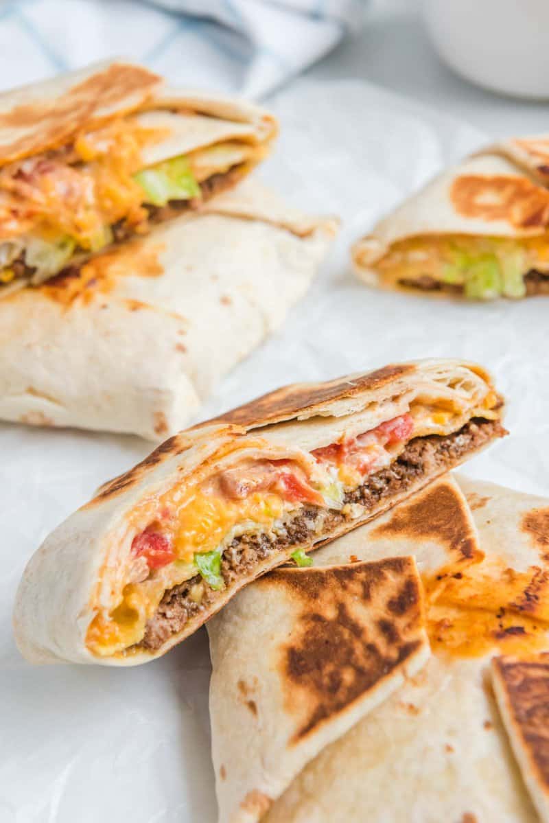 Several copycat Taco Bell crunchwrap supremes whole and cut in half.