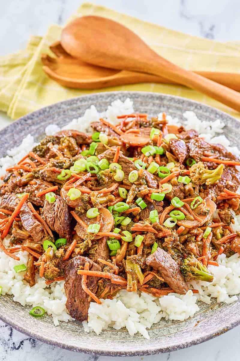 Teriyaki beef stir fry over rice on a plate.