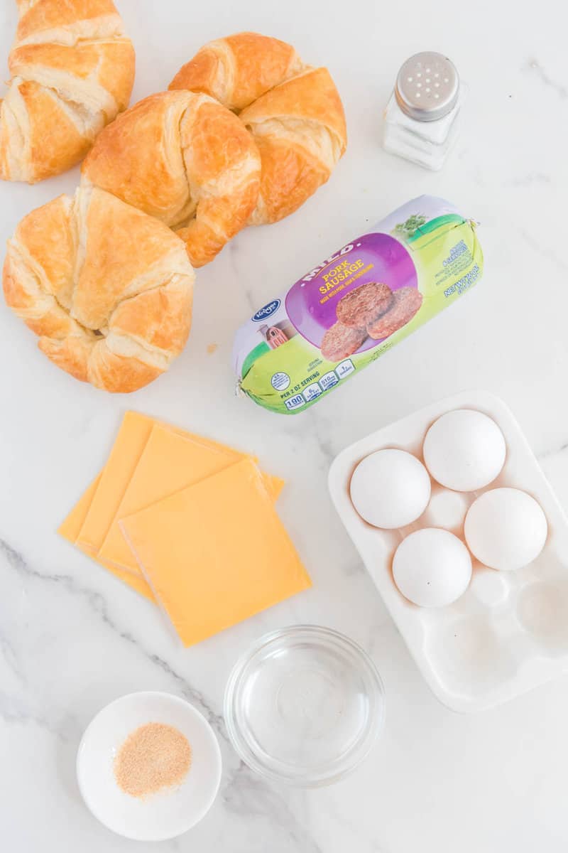 Copycat Burger King sausage egg and cheese croissan'wich ingredients on a marble surface.