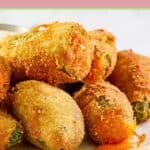 Closeup of deep fried cheddar cheese jalapeno poppers on a plate.