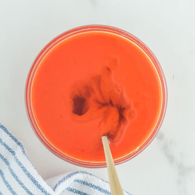 Copycat Chick Fil A Polynesian sauce ingredients and a spoon in a glass bowl.