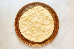Baked pizza dough on a pizza pan.