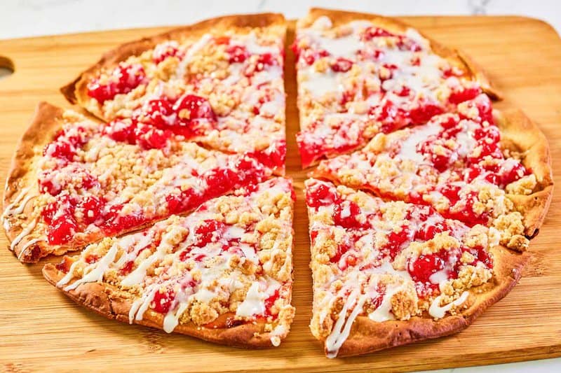 Copycat CiCi's cherry dessert pizza on a wood serving platter.