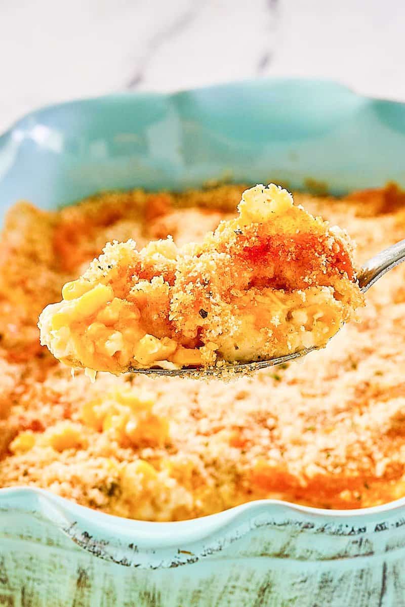 Corn au gratin on a spoon over the dish.