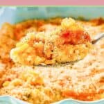 Creamed corn au gratin on a spoon with the dish behind it.