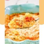 A spoonful of corn au gratin held over the dish of it.