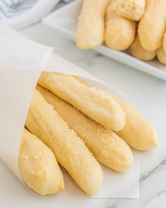Copycat Little Caesars crazy bread wrapped in parchment and on a platter.