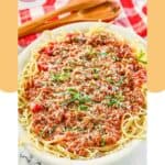 Homemade meat sauce over spaghetti on a platter.