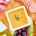 Overhead view of homemade sweet hot mustard on a charcuterie board.
