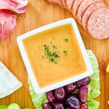 Overhead view of homemade sweet hot mustard on a charcuterie board.