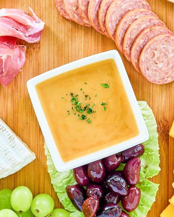 Overhead view of homemade sweet hot mustard on a charcuterie board.