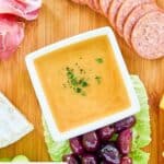 Overhead view of homemade sweet hot mustard on a charcuterie board.