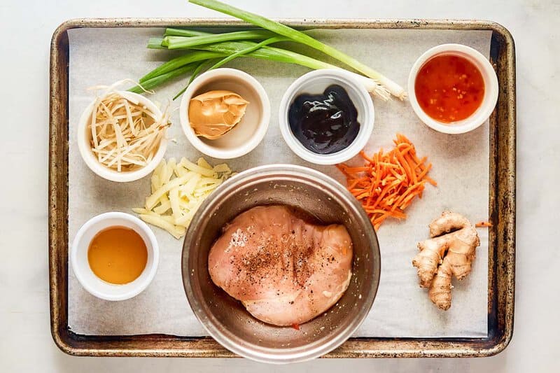 Copycat California Pizza Kitchen Thai chicken pizza ingredients on a tray.