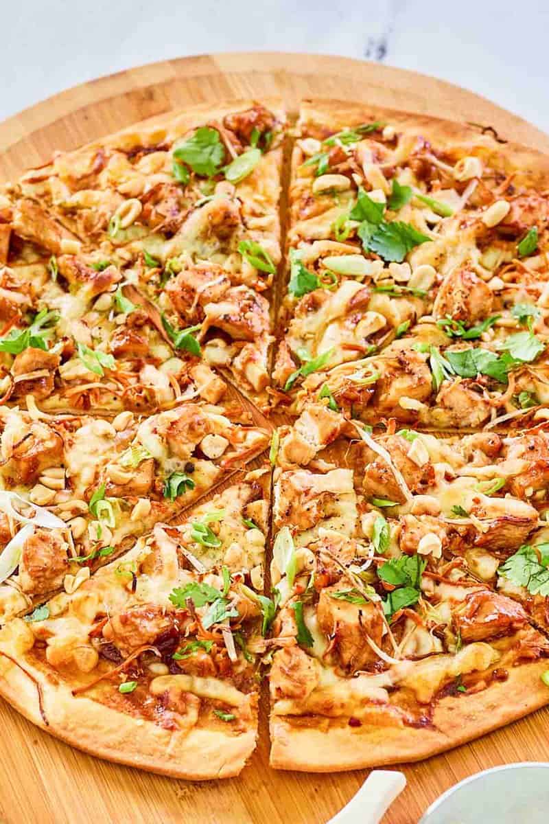 Copycat California Pizza Kitchen Thai chicken pizza on a pizza peel.