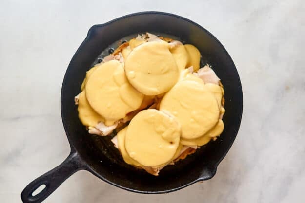 Turkey devonshire sauce over the sandwich in a skillet.