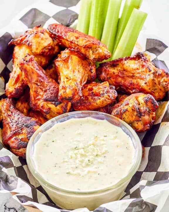 Copycat Wingstop blue cheese dip, chicken wings, and celery sticks.