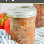 Homemade canned spaghetti sauce in a mason jar on top of a blue striped kitchen towel.