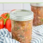 Canned spaghetti sauce in a jar on top of a striped kitchen towel.