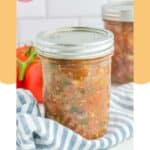 A jar of homemade canned spaghetti sauce on top of a kitchen towel.