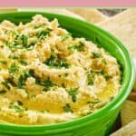 Creamy hummus in a green bowl.
