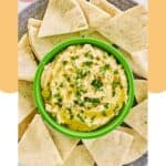 Overhead view of creamy hummus and pita bread on a grey platter.
