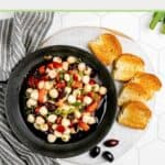 Overhead view of marinated mozzarella balls and toasted bread slices.