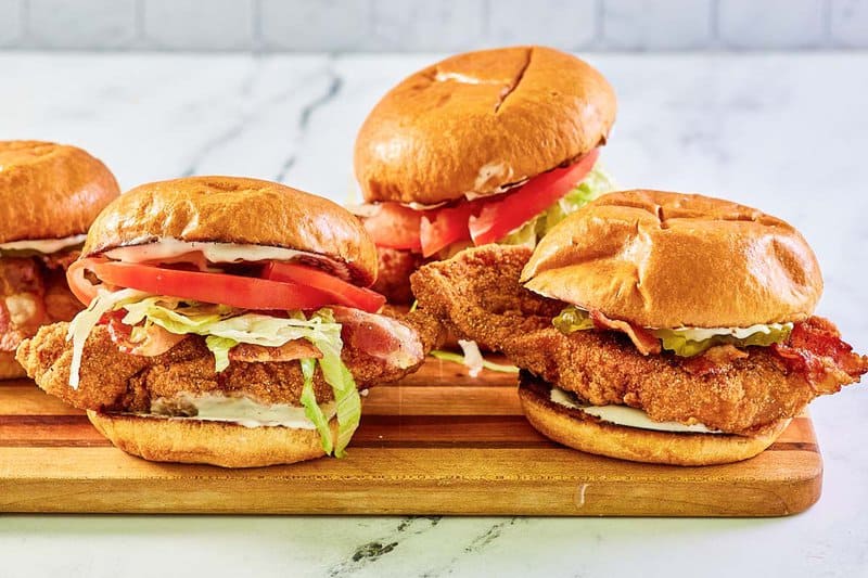 Copycat McDonald's bacon ranch McCrispy sandwiches on a wood board.