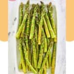 Overhead view of roasted asparagus on a white platter.