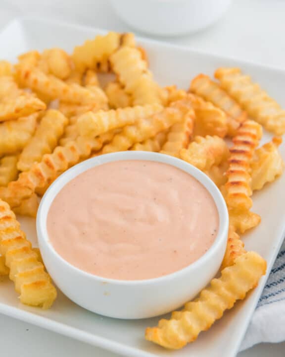 Copycat Raising Cane's sauce and crinkle-cut French fries on a plate.