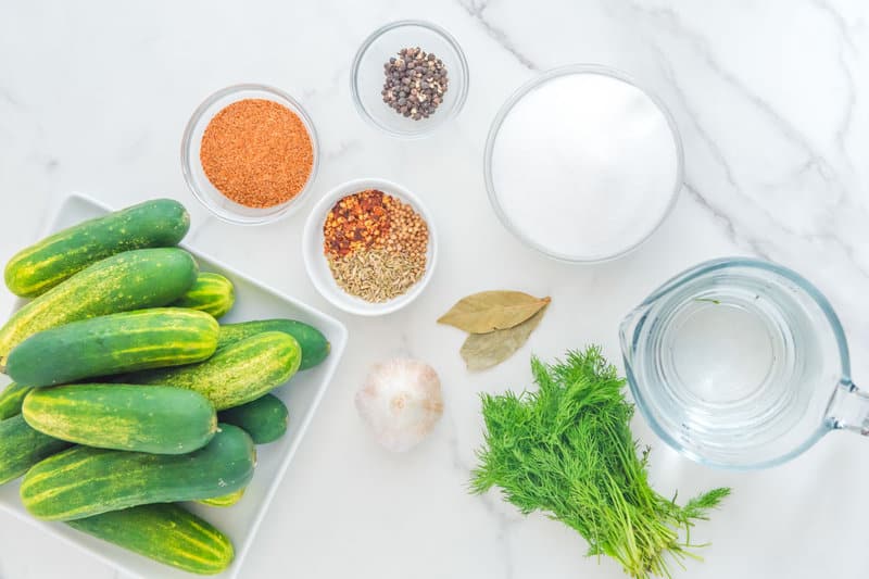 Spicy dill pickles ingredients on a marble surface.