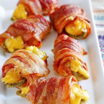 Air fryer bacon wrapped jalapeno poppers on a platter.