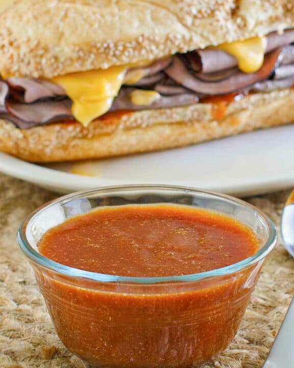 Copycat Arby's sauce in front of a roast beef sandwich.