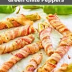 Bacon wrapped cheese stuffed hatch peppers on parchment paper.