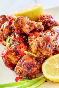 Copycat Buffalo Wild Wings Asian Zing wings and lemons on a plate.